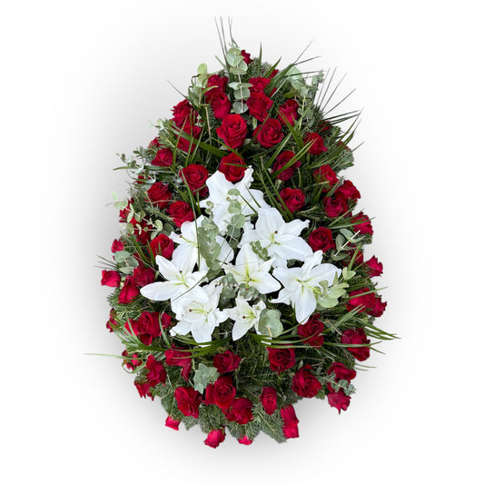 Coroană funerară realizată din trandafiri roșii și din gypsophila și crini albi și ornată cu plante decorative: frunze de eucalipt și Parlor Palme.
